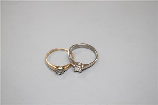 A modern 18ct gold and princess cut solitaire diamond ring and a 585 and solitaire diamond ring, sizes M & L, gross 2.7 grams & 2 g